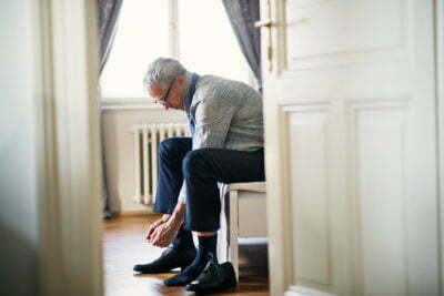Fall Prevention: Elderly man tying his shoes