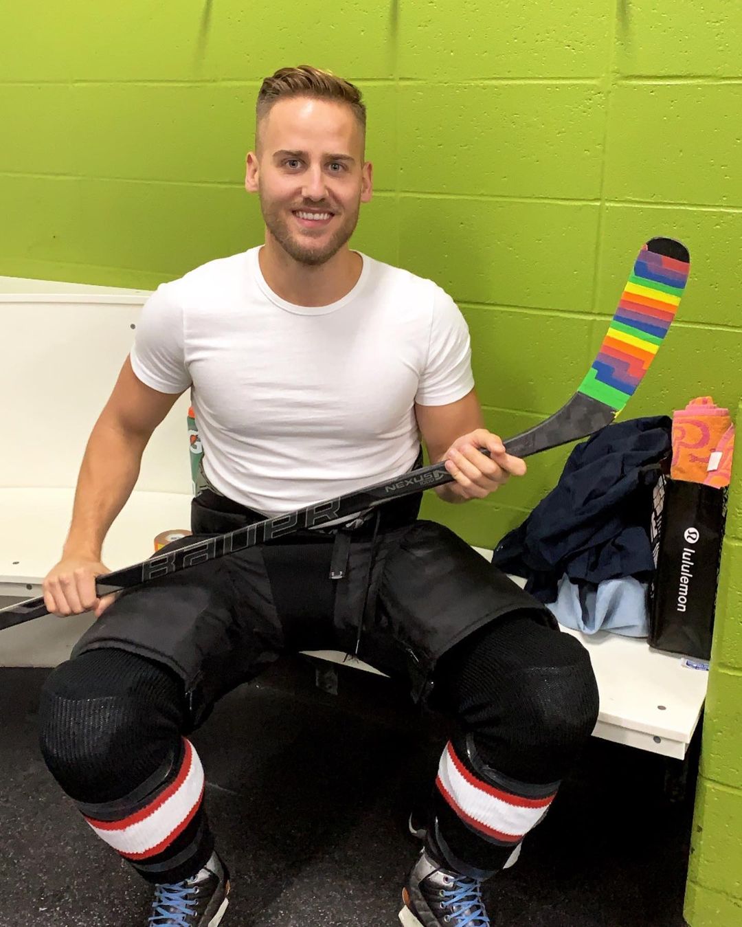 Dr. Brett Lypchuk posing in hockey equipment and holding his hockey stick. 