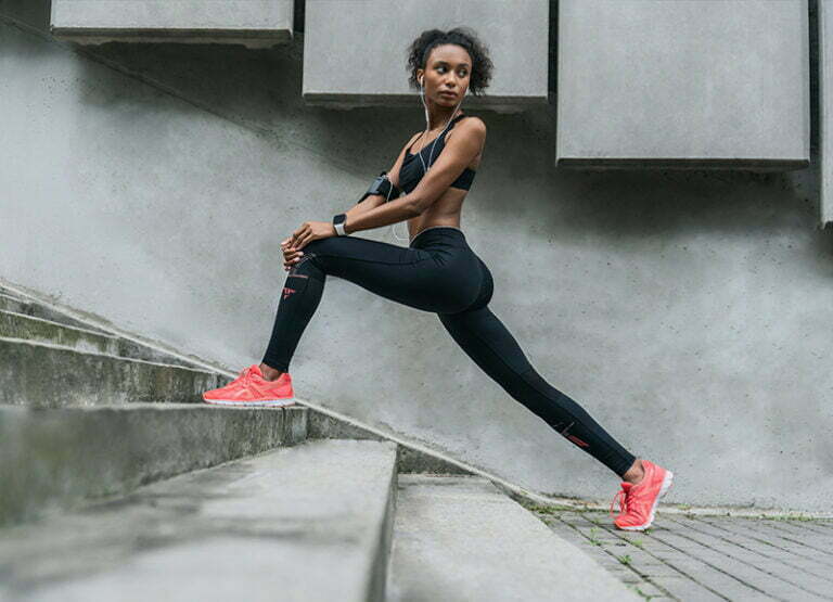 Female runner stretching on stairs.