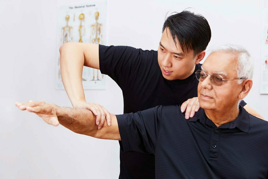 Chiropractor treating an older male adult patient