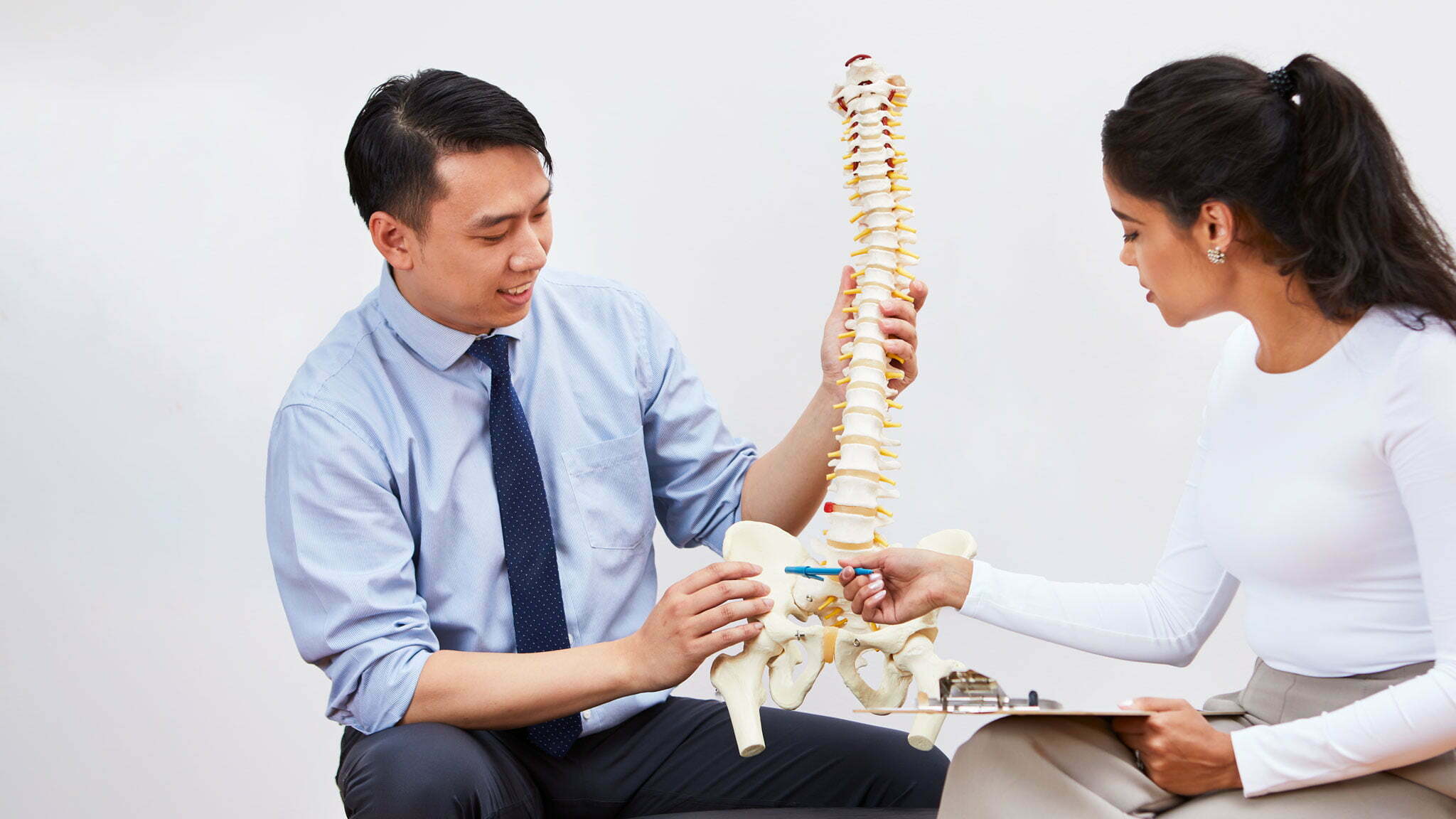 Chiropractors looking at a spine model