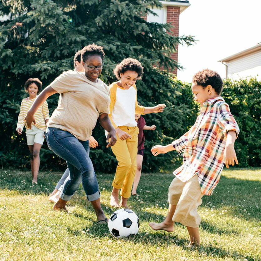 Family playing soccer outside