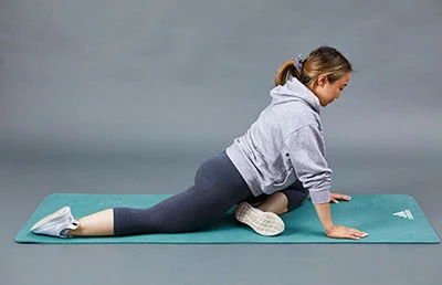 A woman performing a glute stretch