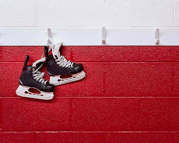Hockey skates hanging on wall.