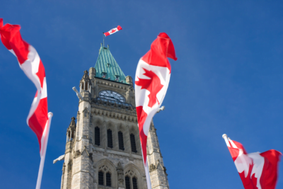 Des drapeaux canadiens flottant autour du Parlement canadien à Ottawa.