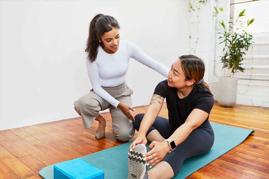 A female chiropractor showing a stretch to a female patient