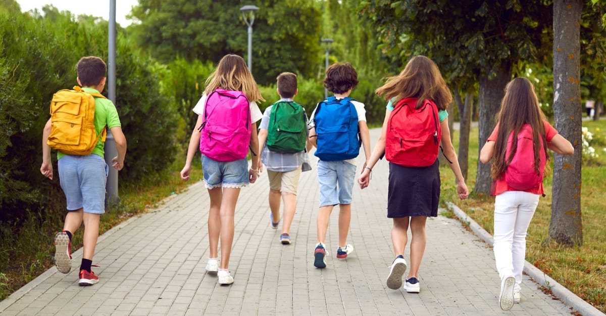 Children wearing backpacks on a path to school. (Photo: Lacheev / iStock)