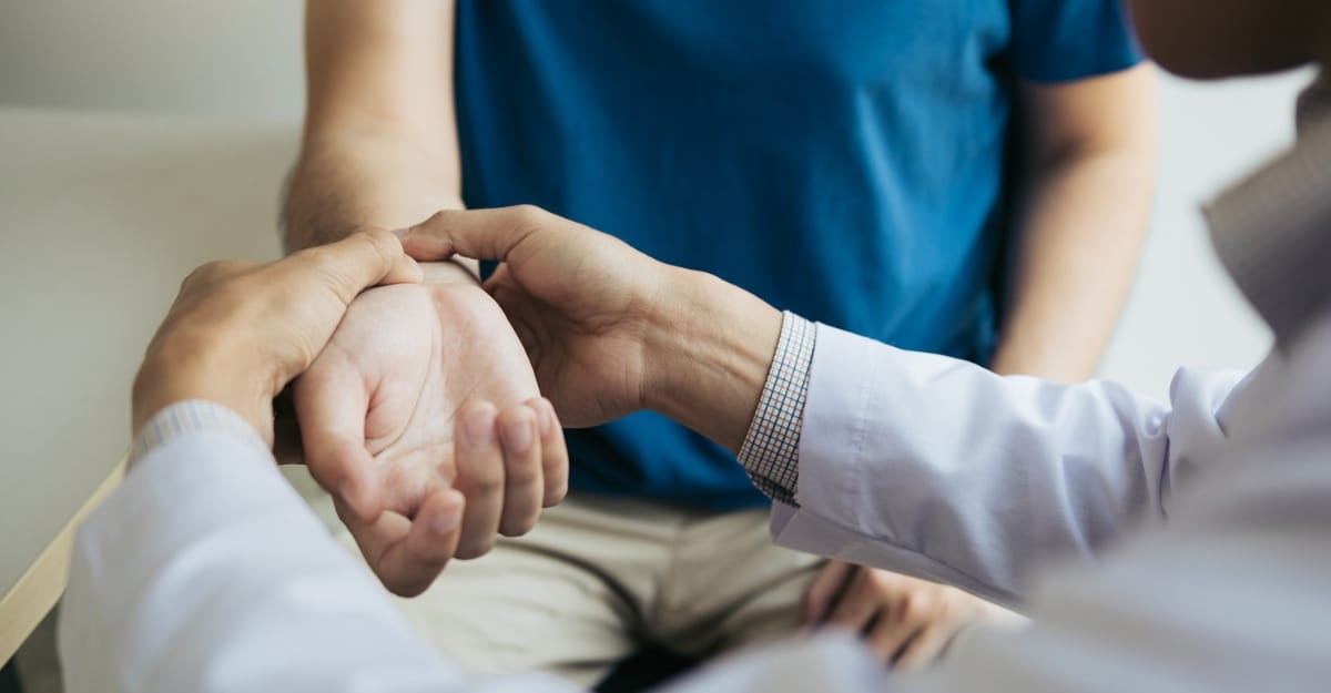 A chiropractor examines a patient's wrist. (Photo: Wutwhanfoto / iStock)