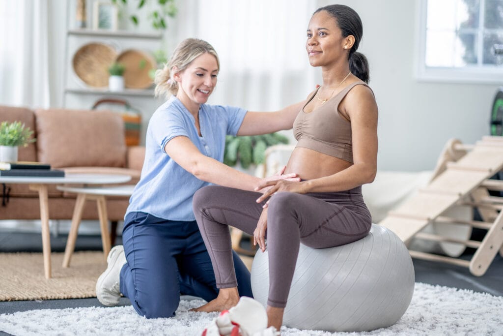 A female chiropractor works with a pregnant woman during an appointment.