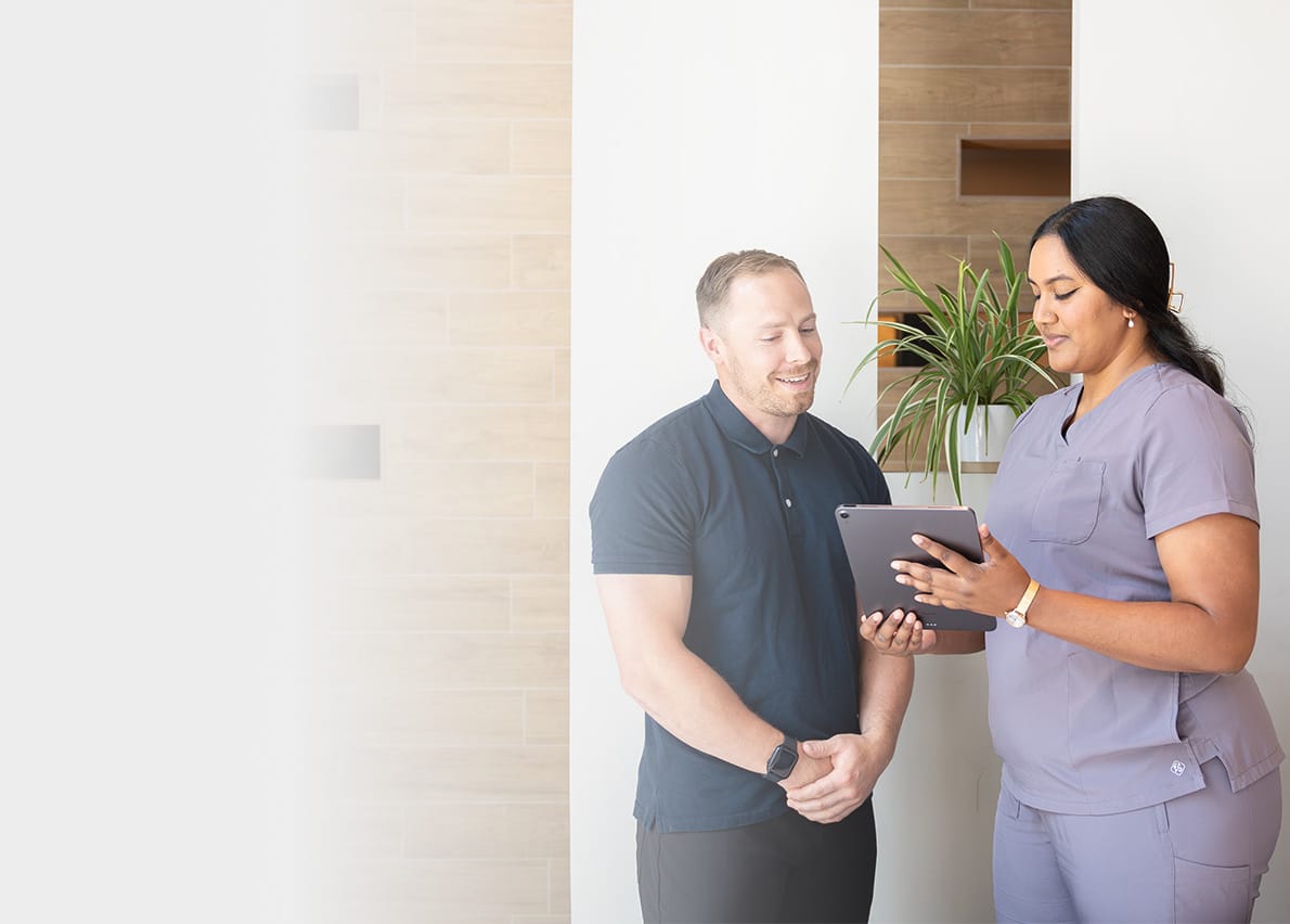 chiropractor and allied healthcare provider reviewing content on a tablet.