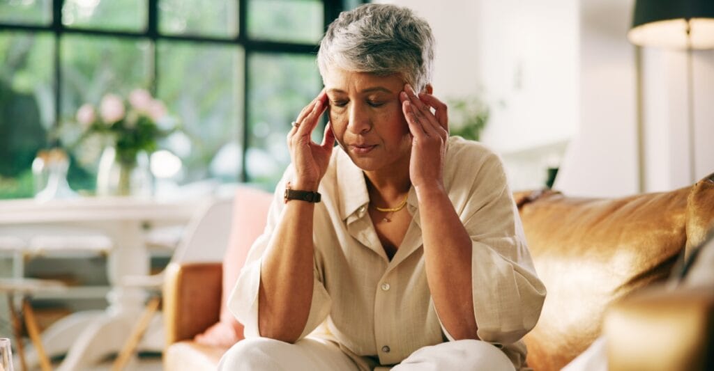 A woman rubs her temples. (Photo: Jacob Wackerhausen / iStock) 