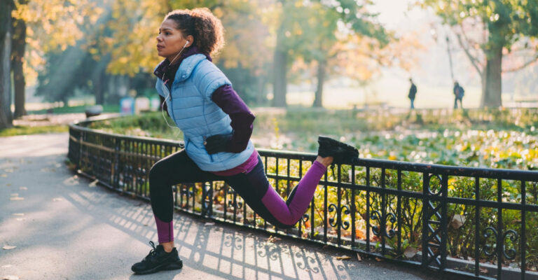 A jogger does a leg stretch at a park. (Photo: 1283893732 / iStock)